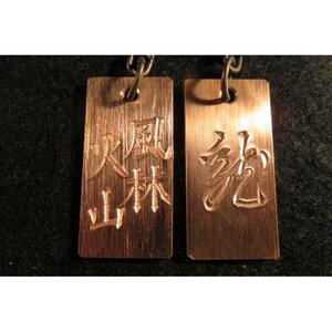 刀匠が銅板のキーホルダーに文字をお入れします。