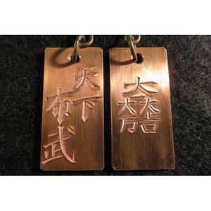 刀匠が銅板のキーホルダーに文字をお入れします。